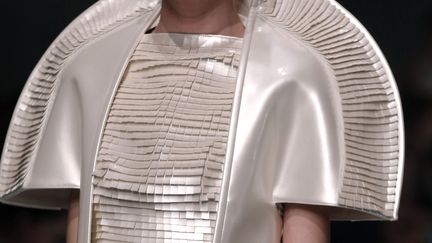 Le britannique Gareth Pugh révélé avec des costumes de théâtre et d'opéra, a présenté une collection très architecturée aux looks futuristes. Les vestes à manches courtes forment des sortes de coques protectrices tandis que les robes portées parfois sur des pantalons fluides, affichent des cols spectaculaires. Le gris, le noir et le blanc dominent avec quelques touches vert émeraude. Le soir, la robe longue se porte avec des manches de fourrure façon grizzly.
 (FRANCOIS GUILLOT / AFP)