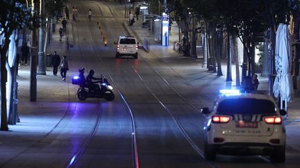 Des voitures de police israéliennes patrouillent dans une rue principale du centre de Jérusalem, le 9 octobre 2023. (THOMAS COEX / AFP)