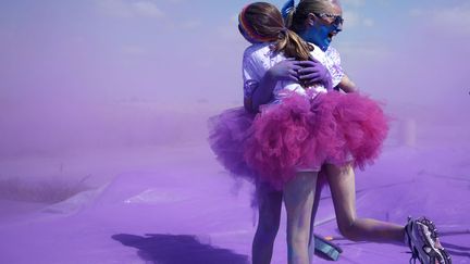 Des participantes &agrave; la "Color Run", une course &agrave; pied pendant laquelle les coureurs sont asperg&eacute;s de pigments color&eacute;s, se congratulent apr&egrave;s avoir franchi la ligne d'arriv&eacute;e &agrave; Irvine (Californie), le 10 mai 2014. (LUCY NICHOLSON / REUTERS)