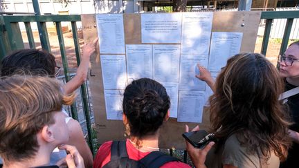 Des lycéens découvrent les résultats de leur admission au baccalauréat devant l'affichage du lycée Camille-Vernet, à Valence (Drôme), le 5 juillet 2022. (NICOLAS GUYONNET / HANS LUCAS / AFP)