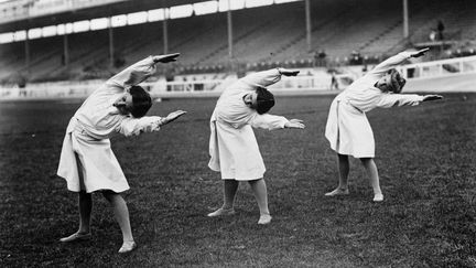 L'&eacute;quipe danoise de gymnastique &agrave; l'&eacute;chauffement. (HULTON ARCHIVE / GETTY IMAGES)