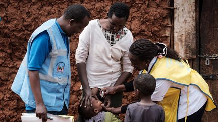 Un garçon reçoit des gouttes de vaccin contre la polio&nbsp;administré par&nbsp;une infirmière à domicile, à Kajiado, au Kenya, le 11 juillet 2018. L'aide au développement a permis l'éradication de cette maladie sur le continent africain. (YASUYOSHI CHIBA / AFP)