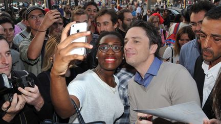 L'acteur et r&eacute;alisateur am&eacute;ricain Zach Braff pose avec une spectatrice &agrave; l'avant-premi&egrave;re de son film "Le R&ocirc;le de ma vie", &agrave; Paris, le 4 ao&ucirc;t 2014. (ANTOINE CAU / SIPA)