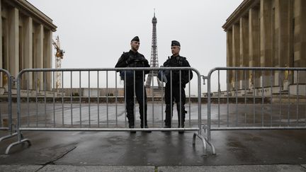 Des policiers patrouillent devant la tour Eiffel, à Paris, le 14 avril 2016.&nbsp; (KENZO TRIBOUILLARD / AFP)