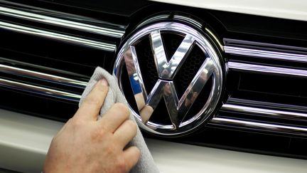 Le logo Volkswagen sur une voiture de la marque nettoyé par un chiffon. (AFP)