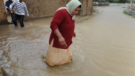 Des habitants inondés sortent de chez eux après les crues d'un oued à Sidi Slimane, près de Kenitra en Fevirer 2009. (AFP)