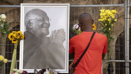 Un habitant vient rendre hommage à l'achevêque Desmond Tutu, dimanche 26 décembre 2021 devant la cathédrale Saint-Georges du Cap (Afrique du Sud). (RODGER BOSCH / AFP)