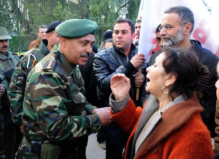 Sihem Bensedrine en discussion avec un officier devant le Parlement à Tunis le 7 février 2011. (STR / AFP)