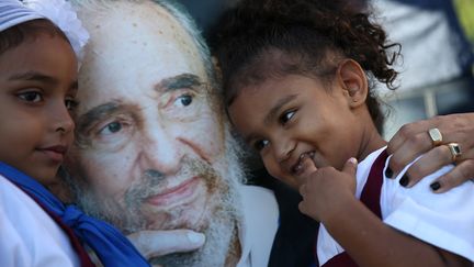 Marian et Chanel Martin posent avec le portrait de Fidel Castro entre elles, après avoir rendu hommage à Fidel Castro au mémorial José Marti, à La Havane (Cuba), mardi 29 novembre 2016. (CARLOS GARCIA RAWLINS / REUTERS)