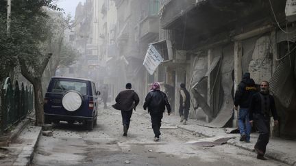 Des habitants courent dans les rues d'un faubourg de Damas, apr&egrave;s un bombardement, le 12 d&eacute;cembre 2013. (MOHAMED ABDULLAH / REUTERS)