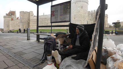 Stuart, sans domicile fixe, est assis dans un abribus devant le château de Windsor (Royaume-Uni), jeudi 4 janvier 2018. (TOBY MELVILLE / REUTERS)