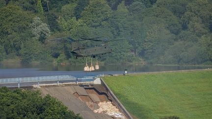 Un hélicoptère de la Royal Air Force largue des sacs de sable pour endiguer l'effondrement du barrage de Toddbrook, dans le nord de l'Angleterre, le 2 août 2019. (ROLAND HARRISON / AFP)