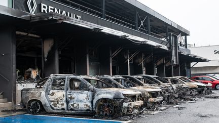 Des carcasses de voitures incendiées devant une concession Renault à Nouméa, le 17 mai 2024. (DELPHINE MAYEUR / AFP)