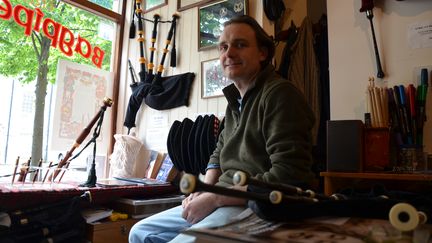 Alan Waldron, propriétaire du magasin Stirling Bagpipes, pose dans sa boutique, le 20 juin 2016, à Stirling (Royaume-Uni). (YANN THOMPSON / FRANCETV INFO)