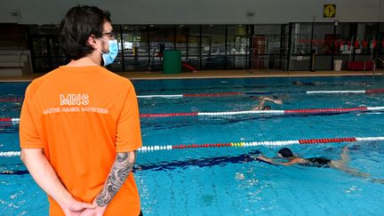 Un maître-nageur portant un masque dans une piscine publique à&nbsp;Chartres-de-Bretagne (Ille-et-Vilaine), le 4 juin 2020. (DAMIEN MEYER / AFP)