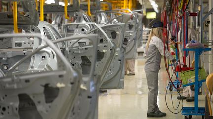 Une salari&eacute;e de PSA Peugeot Citro&euml;n sur une cha&icirc;ne de montage de l'usine de Mulhouse (Haut-Rhin), le 29 avril 2015.&nbsp; (SEBASTIEN BOZON / AFP)