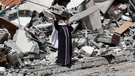 Une femme se tient devant l'immeuble détruit qui abritait les médias AP et Al-Jazeera, à Gaza, le 16 mai 2021. (ADEL HANA / AP / SIPA)