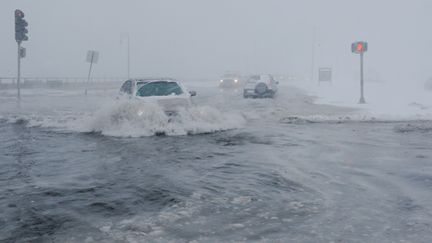 Des automobilistes se frayent un passage sur la route côtière "Beach Road" complètement inondée, à Lynn dans la banlieue de Boston.&nbsp; (BRIAN SNYDER / X90051)