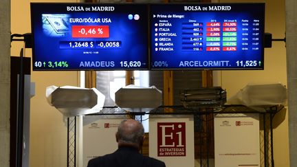 Un homme regarde l'&eacute;volution de l'indice IBEX 35, &agrave;&nbsp;la Bourse de Madrid, le 18 juin 2012. Il a plong&eacute; dans le rouge une heure apr&egrave;s l'ouverture de la Bourse. (JAVIER SORIANO / AFP)