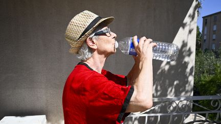 Une femme s'hydrate à Hyères (Var) pendant les fortes chaleurs, le 29 juillet 2024. (MAGALI COHEN / AFP)