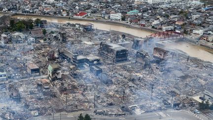 De la fumée s'élève des zones touchées par le séisme à Wajima, dans le centre du Japon, le 2 janvier 2024. Le Premier ministre japonais, Fumio Kishida, a déclaré que les secousses ont fait de "nombreuses victimes" et d'importants dégâts matériels. (FRED MERY / AFP)