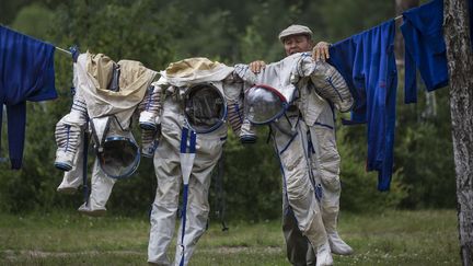 Un employ&eacute; du Centre d'entra&icirc;nement des cosmonautes Youri-Gagarine &eacute;tend les combinaisons d'Anatoly Ivanishin, Kathleen Rubins et Takuya Onishi &agrave; l'issue de leur s&eacute;ance du jour &agrave; Noginsk (Russie), le 2 juillet 2014. (ALEXANDER ZEMLIANICHENKO / AP / SIPA)