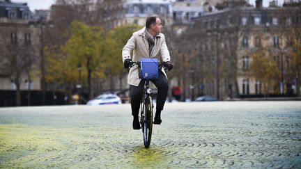 Un homme à vélo place de l'Etoile à Paris le 11 décembre 2015. (MARTIN BUREAU / AFP)