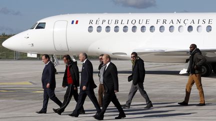 Le pr&eacute;sident de la R&eacute;publique, Fran&ccedil;ois Hollande, les ministres Laurent Fabius et Jean-Yves Le Drian, et les ex-otages, le 31 octobre 2013 &agrave; Villacoublay (Yvelines). (FRANÇOIS GUILLOT / AFP)