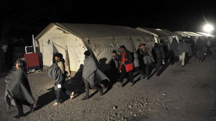 Des migrants traversant la frontière entre la Macédoine et la Grèce, le 9 décembre 2015. (SAKIS MITROLIDIS / AFP)