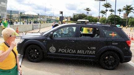 Un&nbsp; véhicule de la police militaire pris pour cible par les émeutiers près du palais présidentiel brésilien. (SERGIO LIMA / AFP)