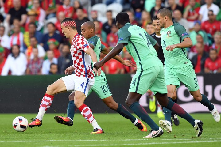 Le milieu de terrain croate Ivan Perisic face à plusieurs joueurs portugais, lors du match Croatie-Portugal à Lens, le 25 juin 2016. (FRANCISCO LEONG / AFP)