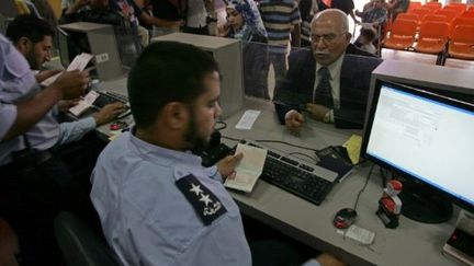 Des douaniers palestiniens contrôlent les papiers de voyageurs au poste-frontière de Rafah (28/05/2011) (AFP / Saïd Khatib)