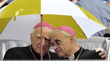 Deux cardinaux se prot&egrave;gent du soleil sur la place Saint-Pierre, au Vatican, le 19 juin 2013. (TIZIANA FABI / AFP)