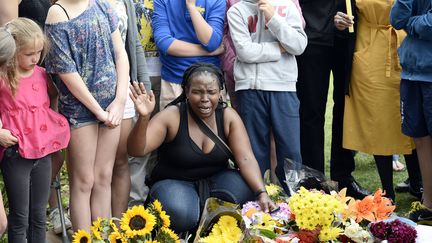 Une femme prie avec &eacute;motion pour Nelson Mandela devant un parterre de fleurs, &agrave; Johannesbourg, le 6 d&eacute;cembre 2013. (STEPHANE DE SAKUTIN / AFP)