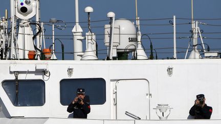 Chinese coast guards take pictures of a Philippine Bureau of Fisheries and Aquatic Resources vessel in the South China Sea on Thursday, Feb. 15, 2024. (TED ALJIBE / AFP)