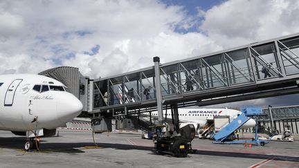 Des passagers apr&egrave;s avoir atterri &agrave; l'a&eacute;roport de Roissy-Charles-de-Gaulle (Val-d'Oise), le 18 ao&ucirc;t 2014.&nbsp; (KENZO TRIBOUILLARD / AFP)