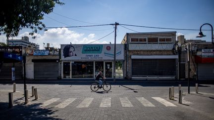 A man rides a bicycle on an empty street in Ashkelon, southern Israel, October 13, 2023. Illustrative photo.  (MARTIN DIVISEK / MAXPPP)