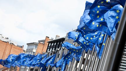 Des drapeaux européens devant le bâtiment où siège de la Commission européenne à Bruxelles, le 12 juin 2022. (KENZO TRIBOUILLARD / AFP)