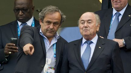 Michel Platini et Sepp Blatter dans les tribunes de la Coupe du monde 2014, à Salvador, le 16 juin 2014. (FRANZ WAELISCHMILLER / SVEN SIMON / DPA PICTURE-ALLIANCE via AFP)