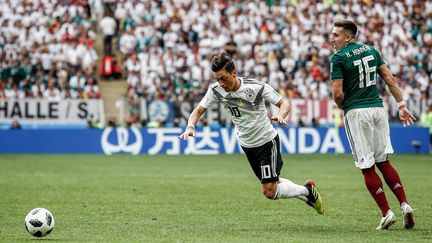 Le meneur de jeu allemand Mesut Özil chute devant un panneau publicitaire en mandarin, lors du match Allemagne-Mexique, le 17 juin 2018 à Moscou (Russie). (PACIFIC PRESS / LIGHTROCKET)