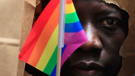 Un demandeur d'asile ougandais avec un drapeau arc-en-ciel lors de la marche des fiert&eacute;s homosexuelles &agrave; Boston (Massachusetts, Etats-Unis), le 8 juin 2013. (JESSICA RINALDI / REUTERS)