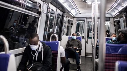 Des passagers assis dans une rame de la ligne 13 du métro parisien, le 23 avril 2020. (MARTIN BUREAU / AFP)