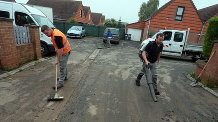 Les habitants de la commune de Haisnes (Pas-de-Calais) nettoient une rue, le 8 juin 2016. (MAXPPP)