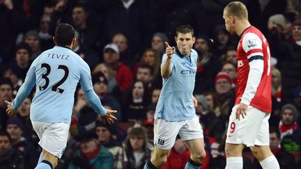 James Milner vient d'ouvrir le score pour City devant un Podolski dépité.  (ADRIAN DENNIS / AFP)