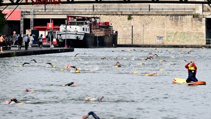 Des nageurs dans le bassin de la Villette, à Paris, le 17 juin 2023. (STEFANO RELLANDINI / AFP)