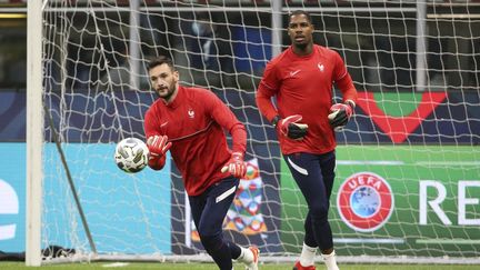 Les gardiens de l'équipe de France Hugo Lloris (à gauche) et Mike Maignan (à droite) à l'entraînement avant une rencontre de Ligue des nations, le 9 octobre 2021. (JEAN CATUFFE / AFP)