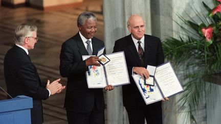 Nelson Mandela et le pr&eacute;sident sud-africain Frederik de Klerk recoivent le prix nobel de la paix le 9 d&eacute;cembre 1993 &agrave; Oslo. Ils sont r&eacute;compens&eacute;s pour la fin de l'appartheid, abrog&eacute; en 1991 apr&egrave;s des n&eacute;gociations entre les deux parties. (GERARD JULIEN / AFP)