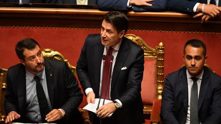 Le Premier ministre italien Giuseppe Conte (au centre), avec le ministre de l'Intérieur Matteo Salvini (à gauche) et le ministre du développement économique, du travail et des politiques sociales Luigi Di Maio (à droite), lors d'un discours solennel annonçant la fin du gouvernement de coalition, le 20 août 2019 à Rome (Italie).&nbsp; (ANDREAS SOLARO / AFP)