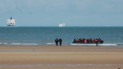 Des policiers et une embarcation de migrants, sur une plage de Sangatte (Pas-de-Calais), le 18 juillet 2023 (illustration). (BERNARD BARRON / AFP)