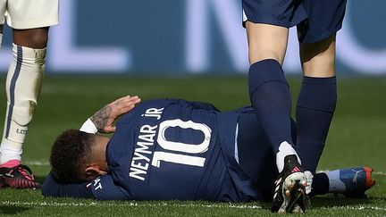 Le Brésilien Neymar au sol, blessé à la cheville lors du match de Ligue 1 PSG-Lille, le 19 février 2023 au Parc des Princes. (FRANCK FIFE / AFP)